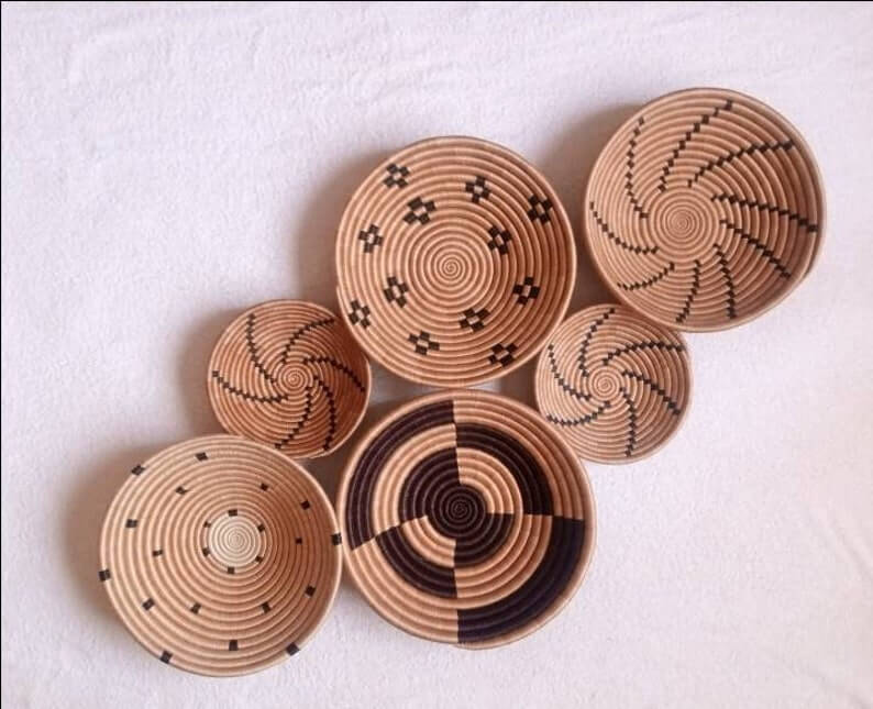 A vibrant set of 6 handwoven Rwanda African wall baskets made from sisal grass, showcasing intricate patterns and natural dyes.