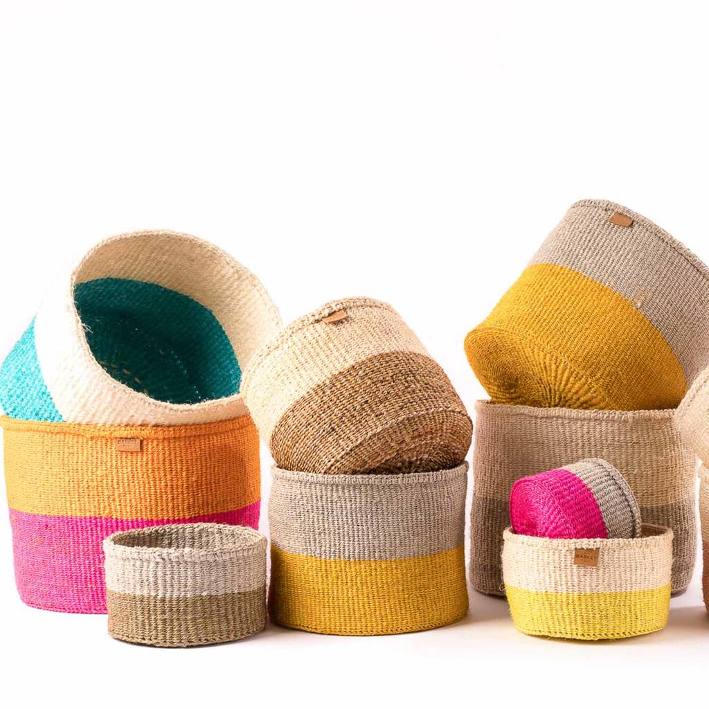 A set of three handwoven African sisal storage baskets in varying sizes, showcasing natural and hand-dyed colors, perfect for stylish organization.