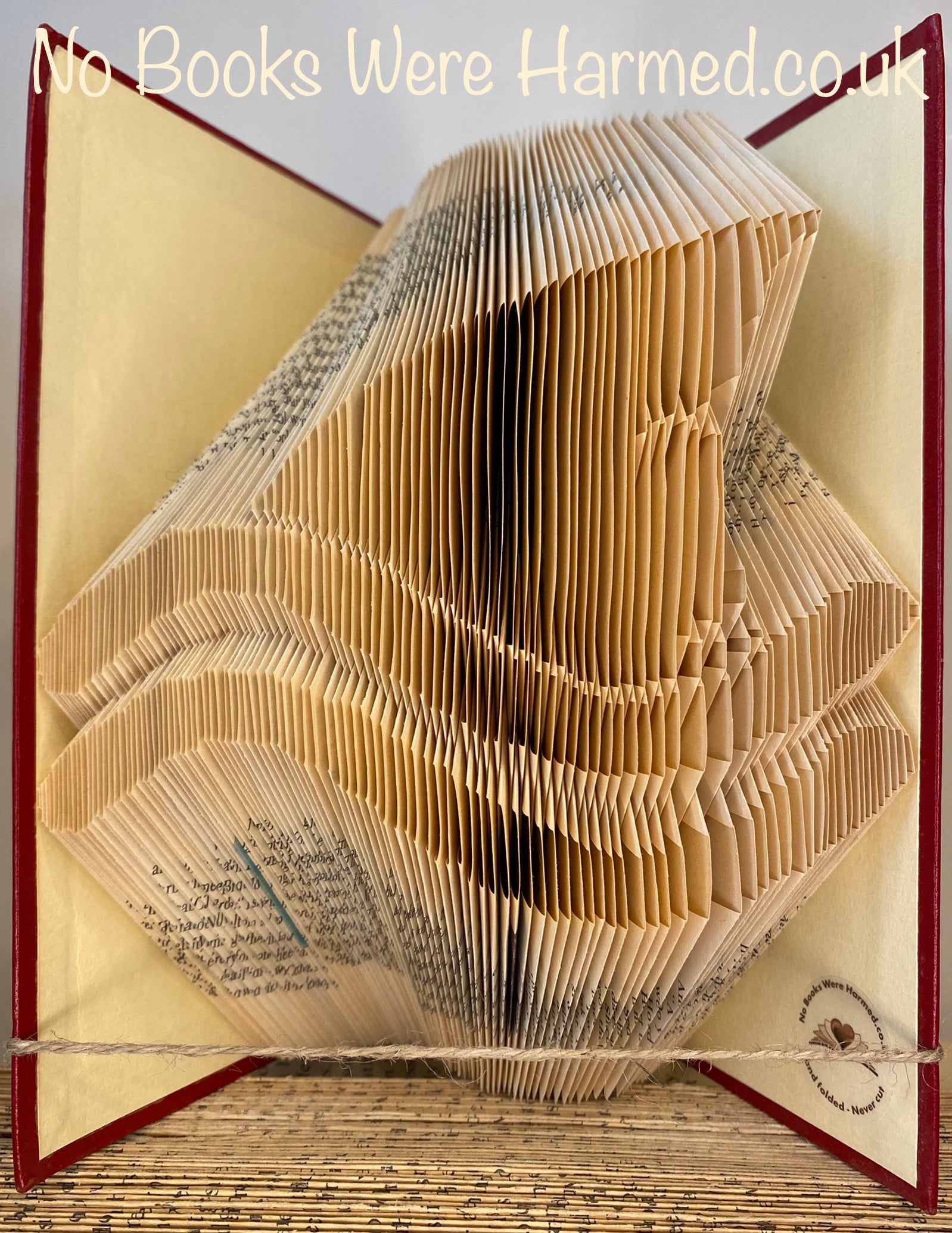 Hand folded shark fin book art made from vintage books, showcasing intricate folds and unique design.