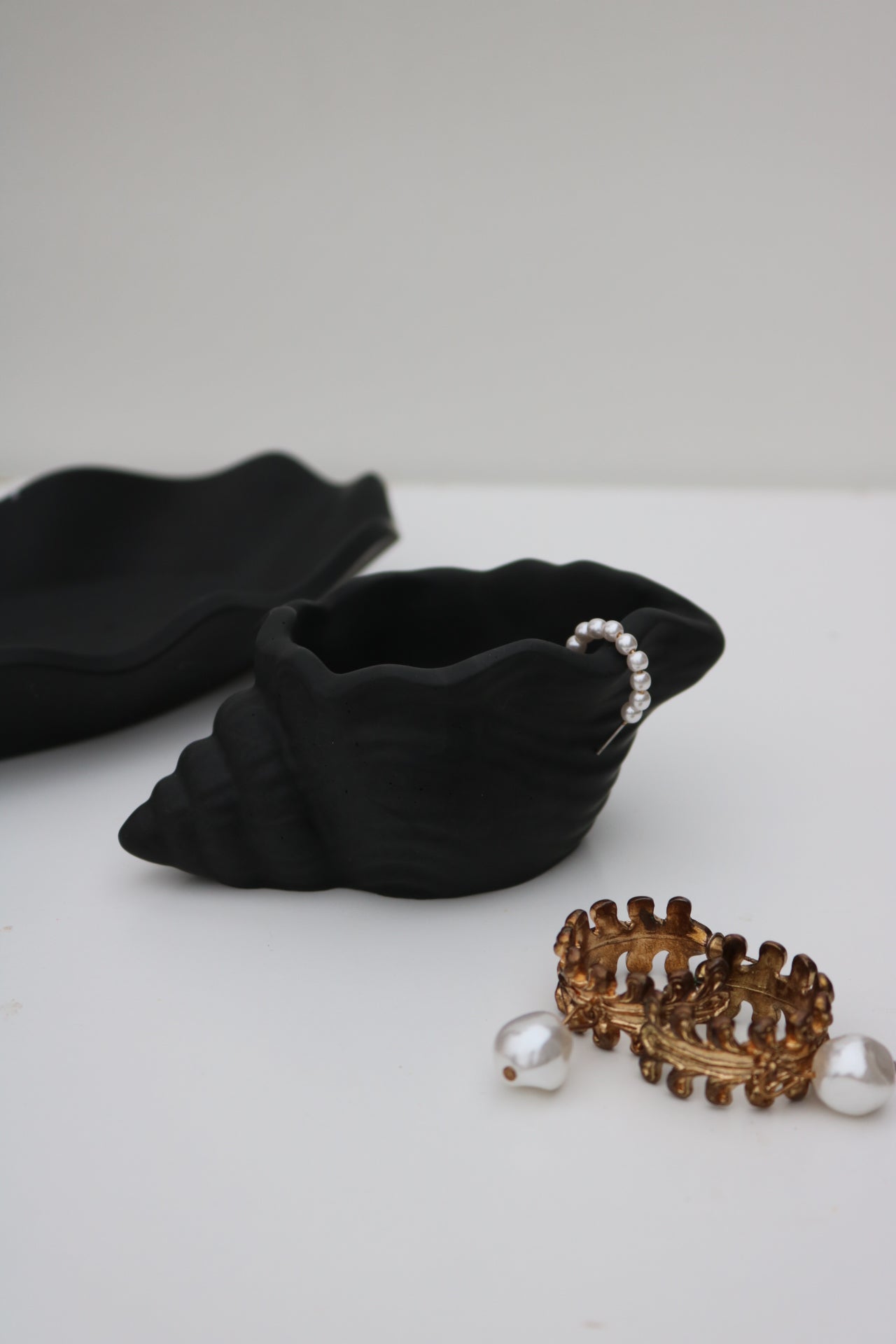 A beautifully crafted shell trinket dish in a soft color, perfect for holding jewelry and accessories, showcasing its unique hand-made finish.