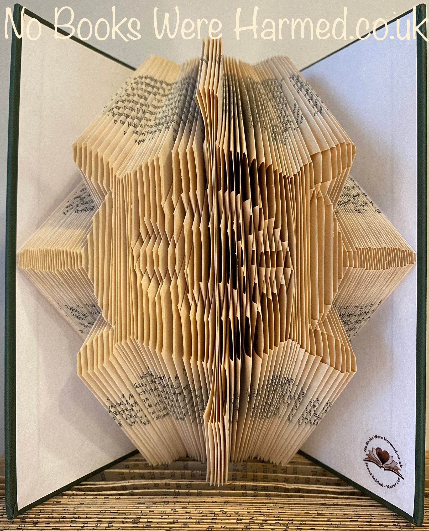 Handcrafted Ship's Wheel art made from vintage book pages, showcasing intricate folds and unique design.