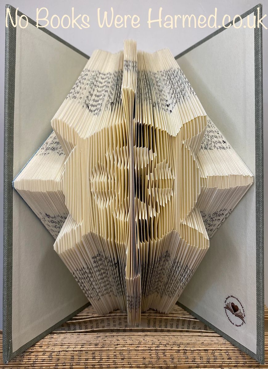 Handcrafted Ship's Wheel art made from vintage book pages, showcasing intricate folds and unique design.
