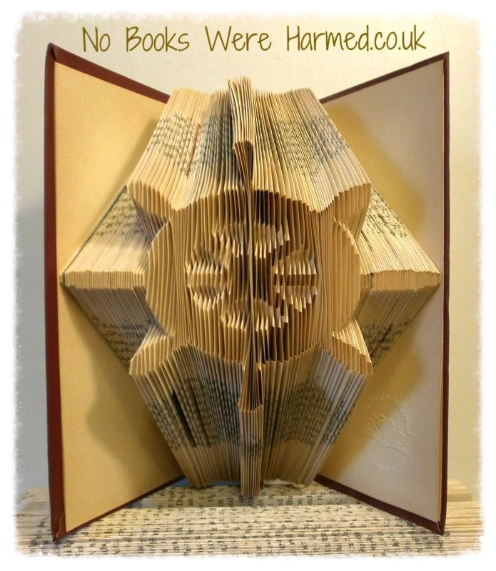 Handcrafted Ship's Wheel art made from vintage book pages, showcasing intricate folds and unique design.