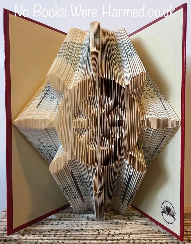 Handcrafted Ship's Wheel art made from vintage book pages, showcasing intricate folds and unique design.