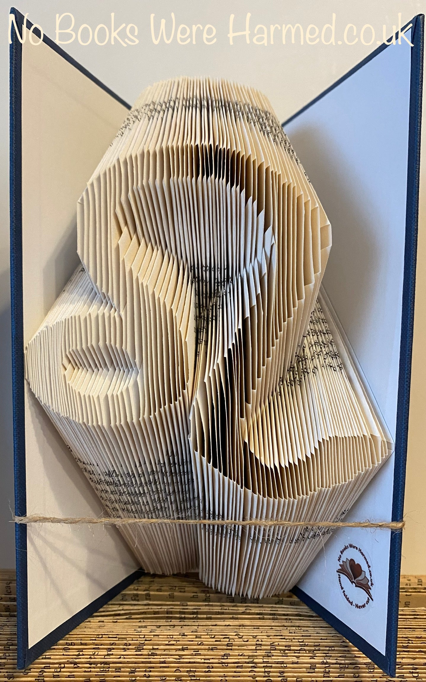 A beautifully crafted zodiac horoscope book featuring hand-folded pages from vintage books, showcasing intricate designs of the twelve zodiac signs.