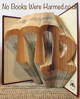 A beautifully crafted zodiac horoscope book featuring hand-folded pages from vintage books, showcasing intricate designs of the twelve zodiac signs.