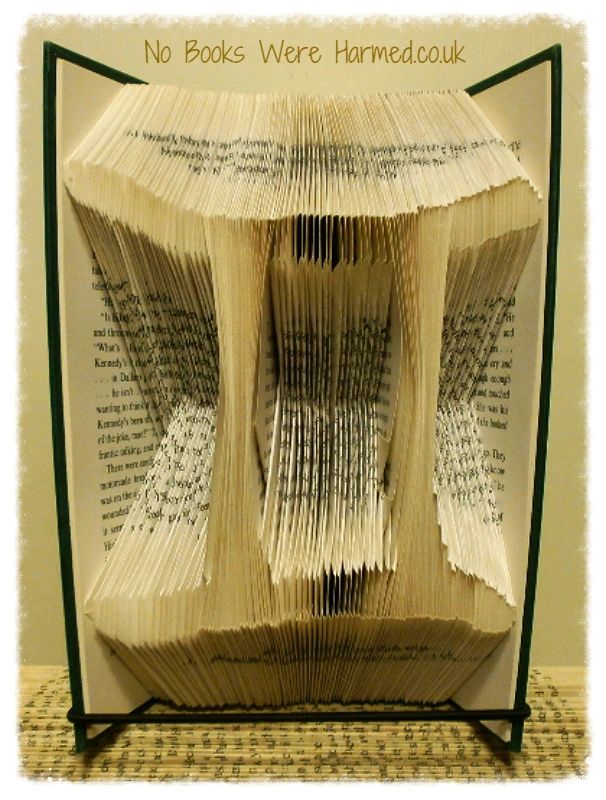 A beautifully crafted zodiac horoscope book featuring hand-folded pages from vintage books, showcasing intricate designs of the twelve zodiac signs.