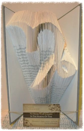 A beautifully crafted zodiac horoscope book featuring hand-folded pages from vintage books, showcasing intricate designs of the twelve zodiac signs.