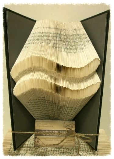 A beautifully crafted zodiac horoscope book featuring hand-folded pages from vintage books, showcasing intricate designs of the twelve zodiac signs.