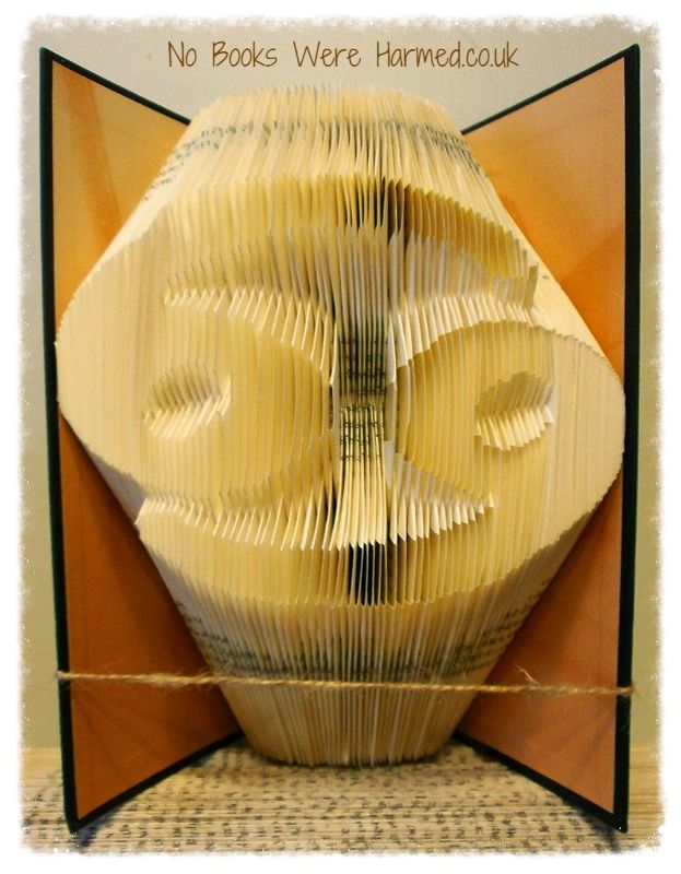 A beautifully crafted zodiac horoscope book featuring hand-folded pages from vintage books, showcasing intricate designs of the twelve zodiac signs.