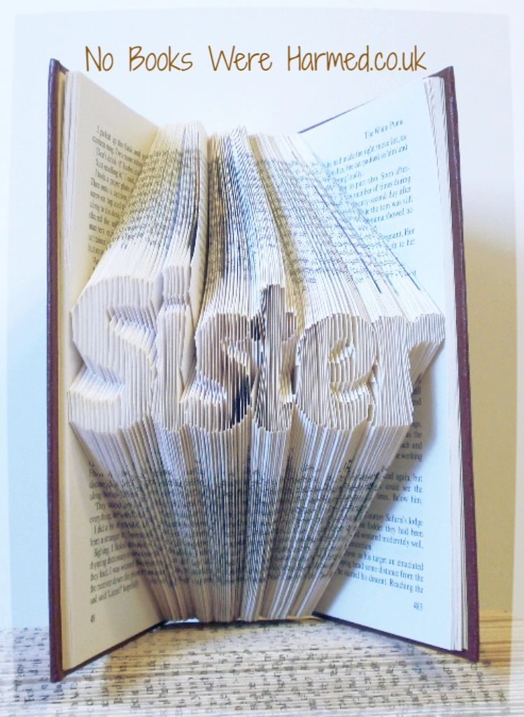 Hand-folded book art titled 'Sister', showcasing intricate designs made from reclaimed vintage books.