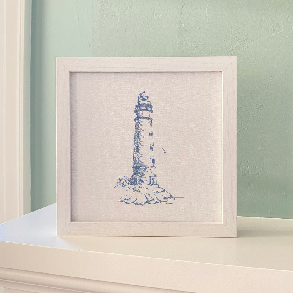 A round framed sign featuring a sketched lighthouse design, with a natural wood frame available in walnut or white-washed finish.