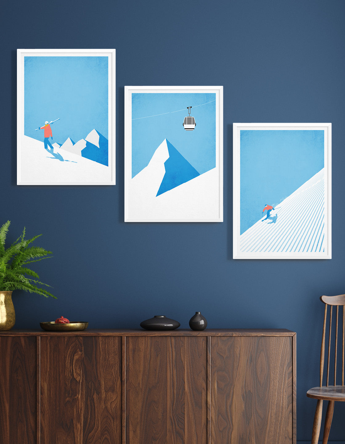 A collection of vintage ski art prints displayed in a stylish gallery wall, showcasing winter landscapes and retro ski scenes.