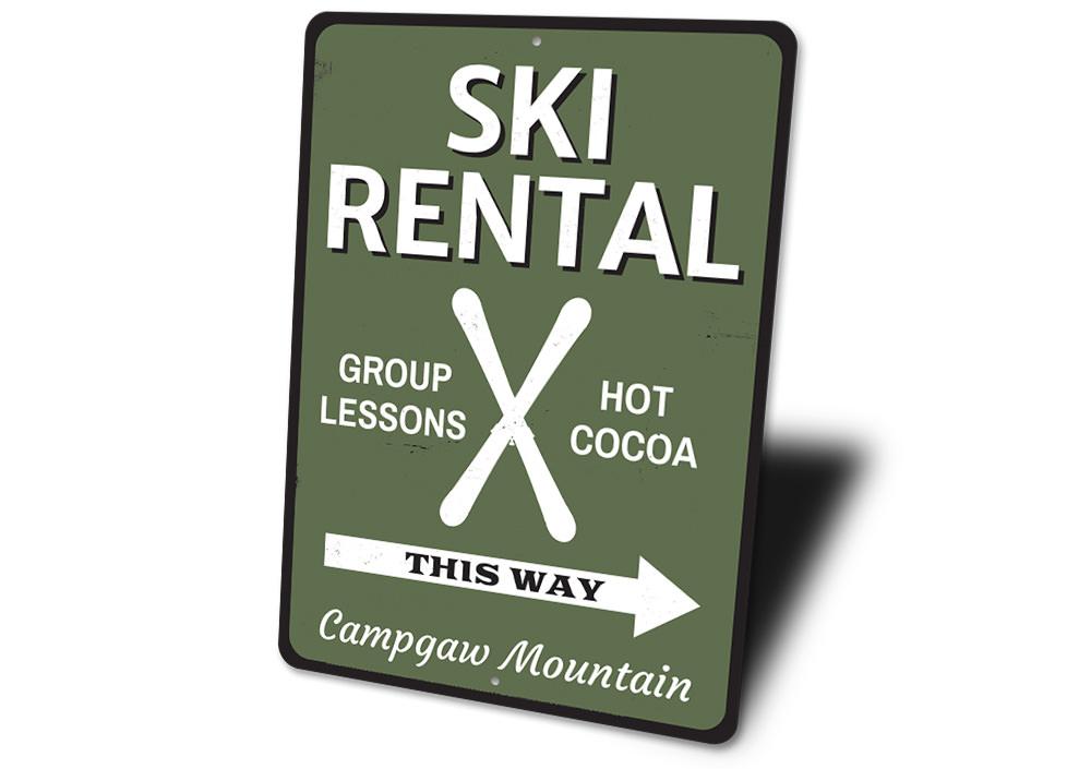 A decorative Ski Rental This Way Sign made of durable aluminum, featuring customizable text and pre-drilled holes for easy mounting.