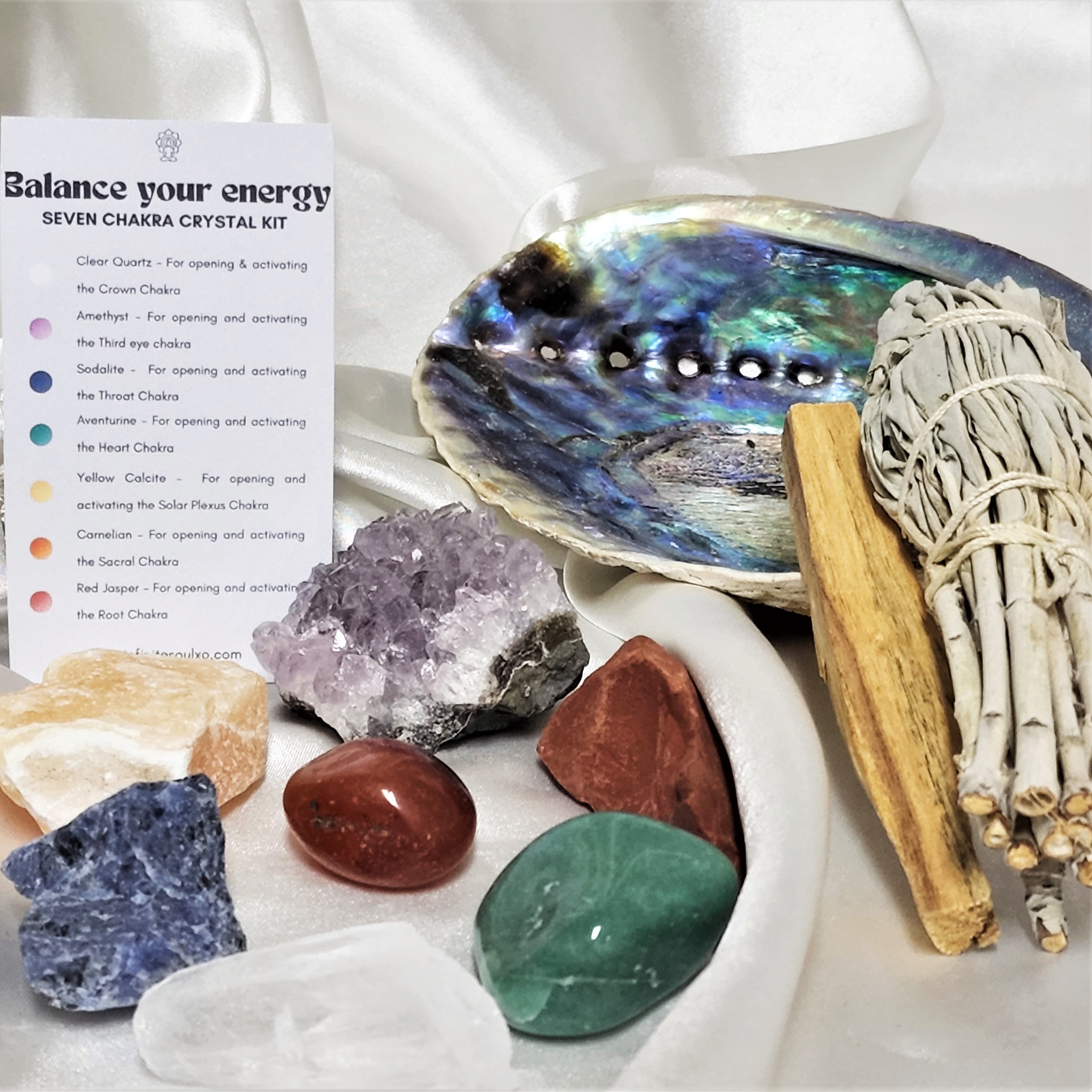Seven Chakra Smudge Kit featuring sage, palo santo, abalone shell, and various chakra crystals for energy balancing.