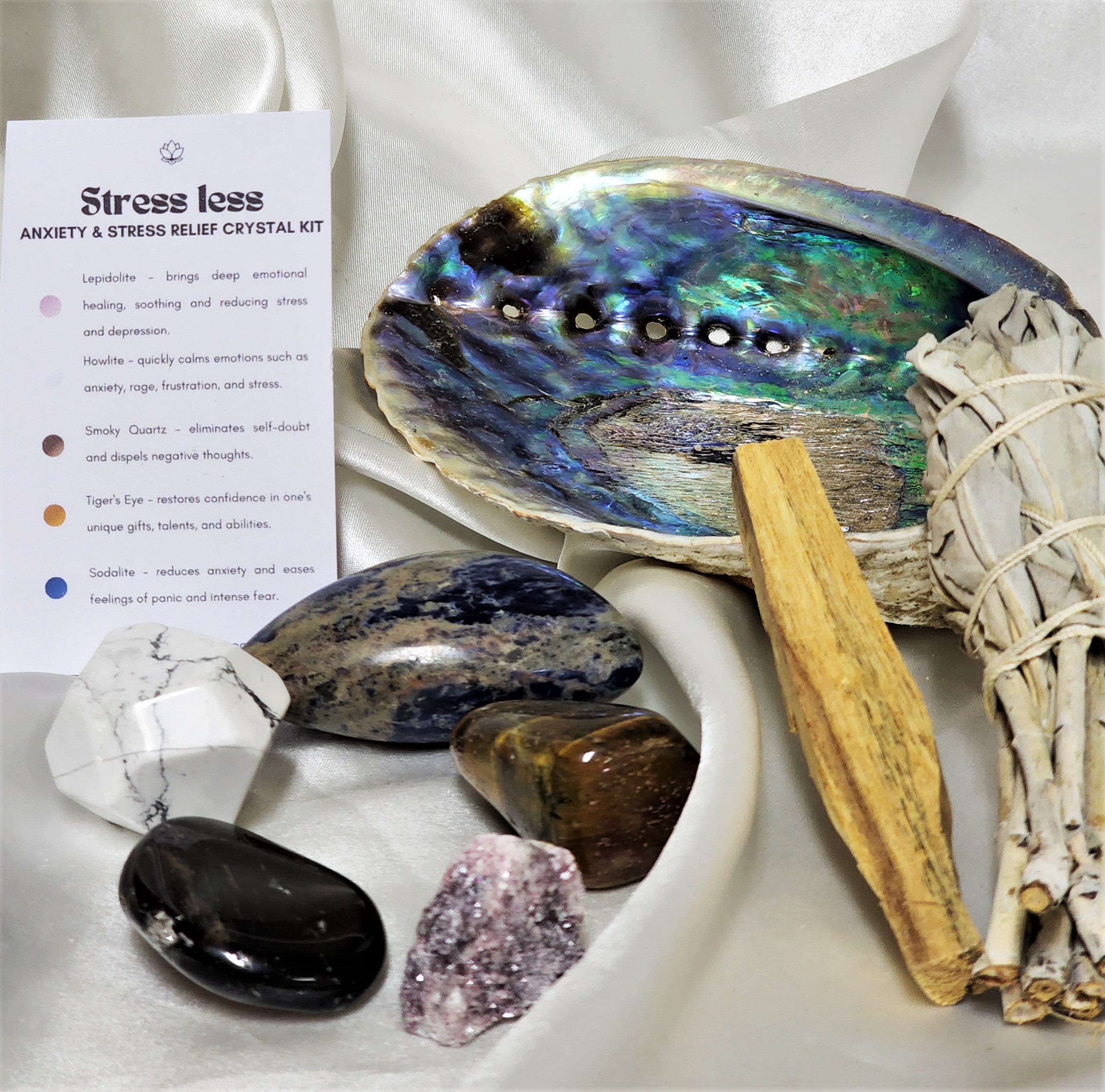 Smudge Kit: Stress Less featuring sage smudge stick, Palo Santo, abalone shell, and various healing crystals for anxiety relief.