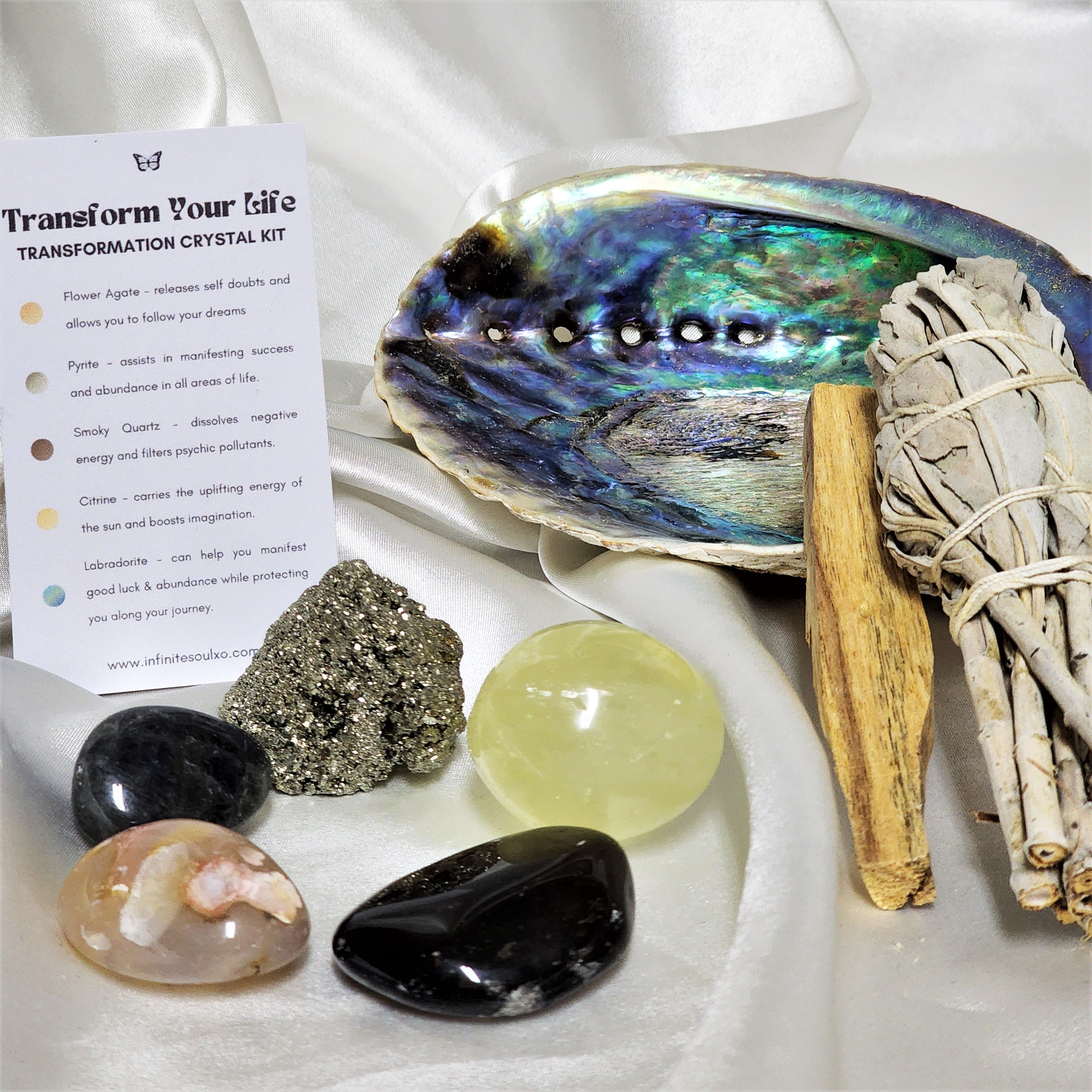 Transformation Smudge Kit featuring sage, palo santo, abalone shell, and various crystals for cleansing and positive energy.