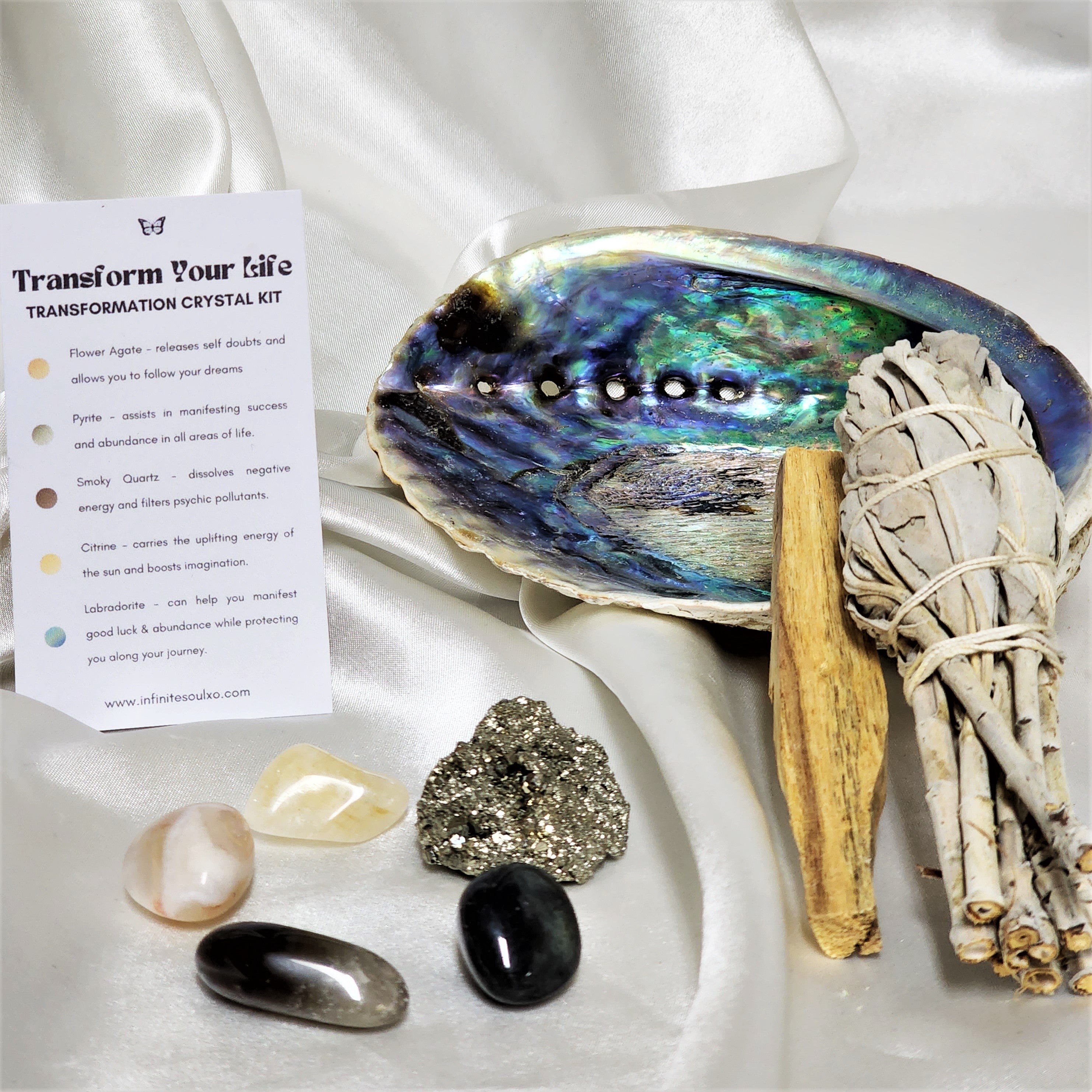Transformation Smudge Kit featuring sage, palo santo, abalone shell, and various crystals for cleansing and positive energy.