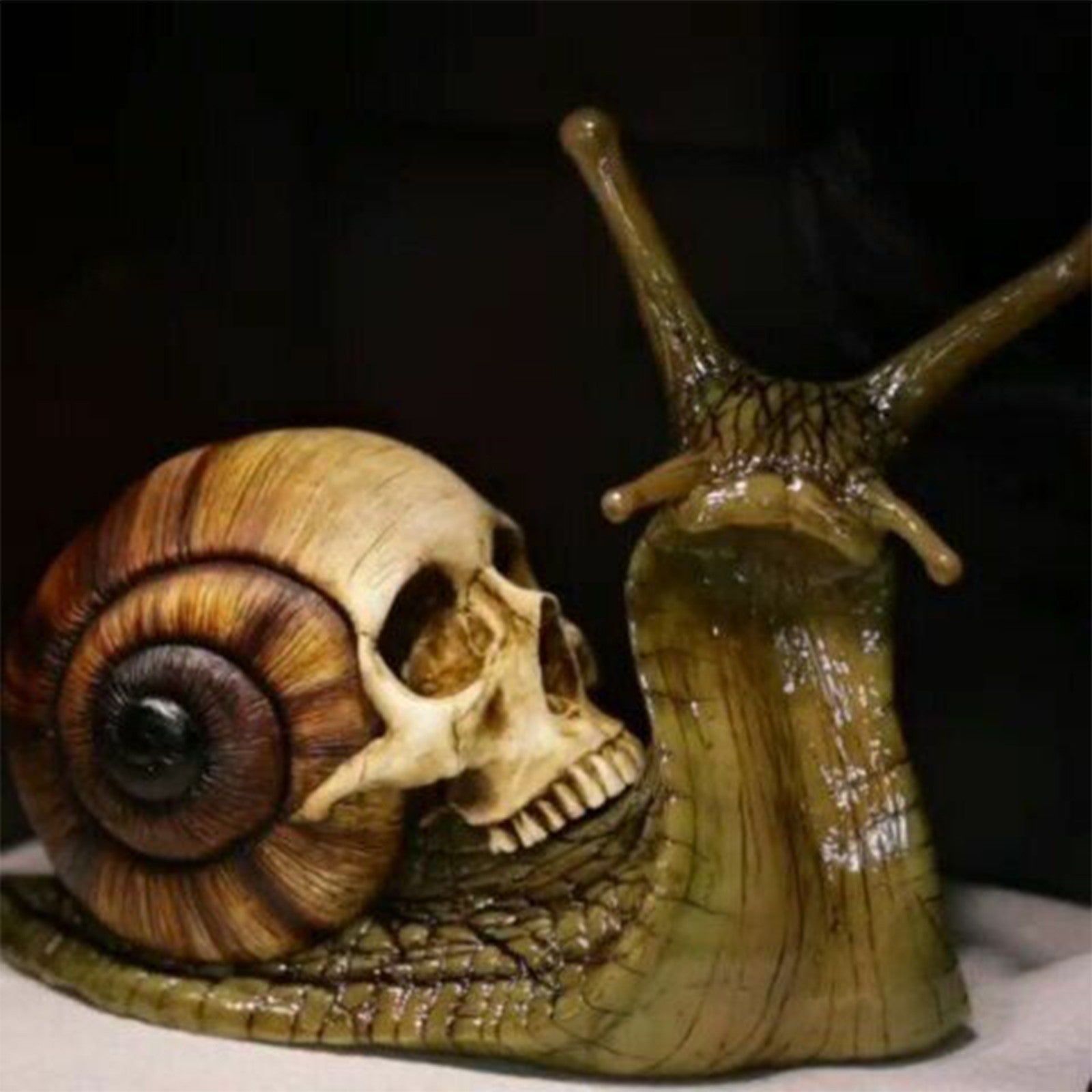 Intricately designed Snail Skull Sculpture in gothic style, showcasing a snail with a skull-shaped shell, perfect for garden or home decor.