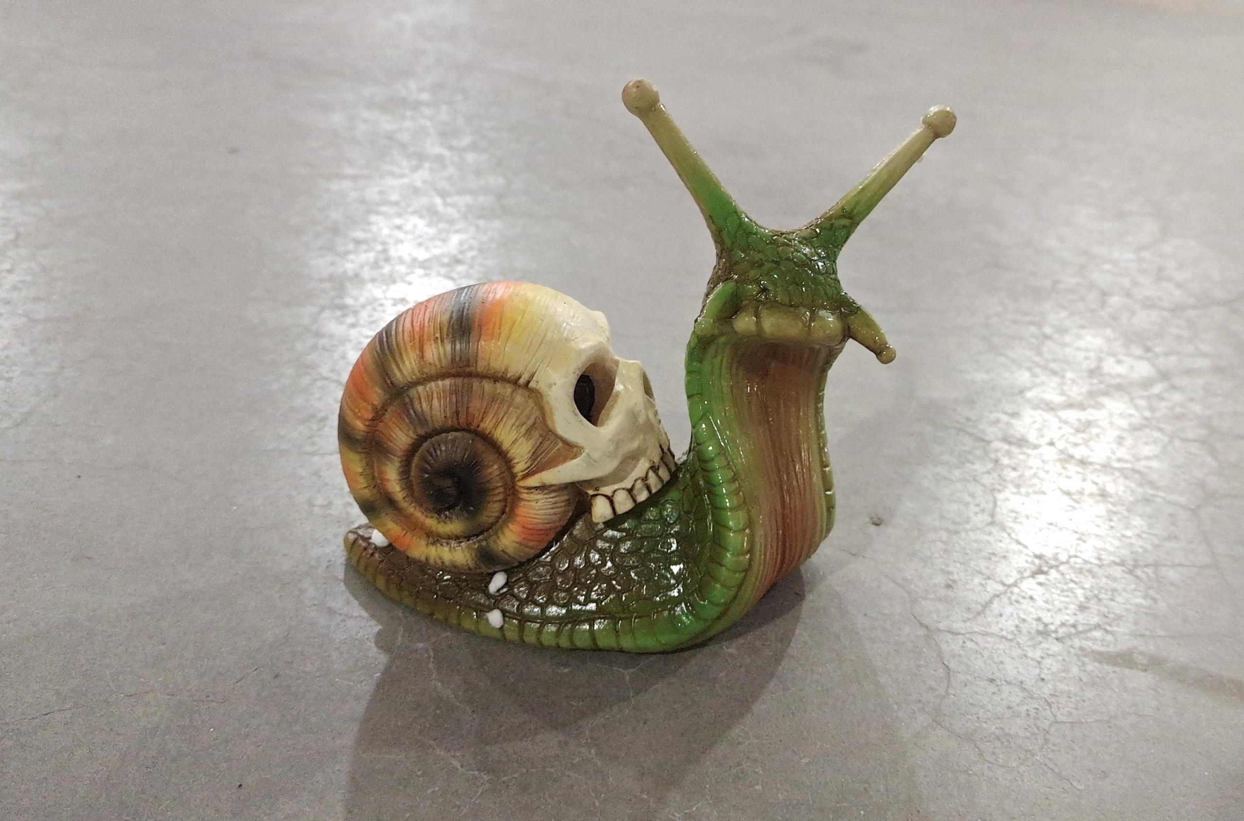 Intricately designed Snail Skull Sculpture in gothic style, showcasing a snail with a skull-shaped shell, perfect for garden or home decor.