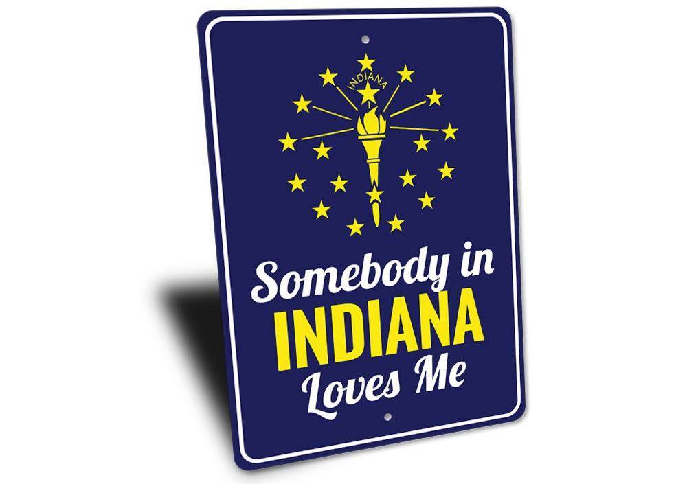 A decorative aluminum sign reading 'Somebody in Indiana Loves Me', showcasing vibrant colors and a charming design, perfect for home decor.