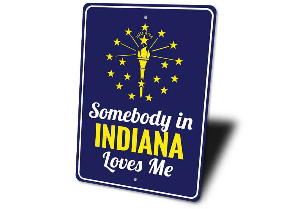 A decorative aluminum sign reading 'Somebody in Indiana Loves Me', showcasing vibrant colors and a charming design, perfect for home decor.
