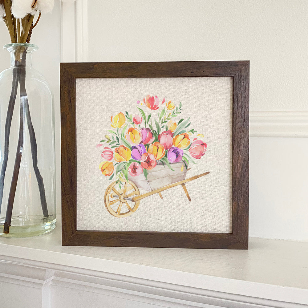 Spring Floral Wheelbarrow framed sign with a rustic wood frame and linen-look background, featuring vibrant floral designs.