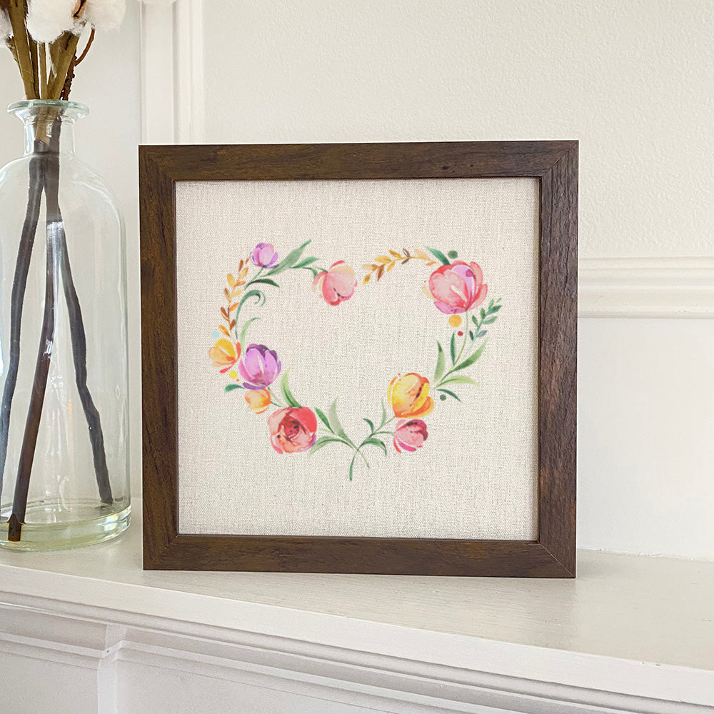 A beautifully framed Spring Heart Wreath sign with a natural wood frame, featuring eco-friendly ink printing on a linen-look background.