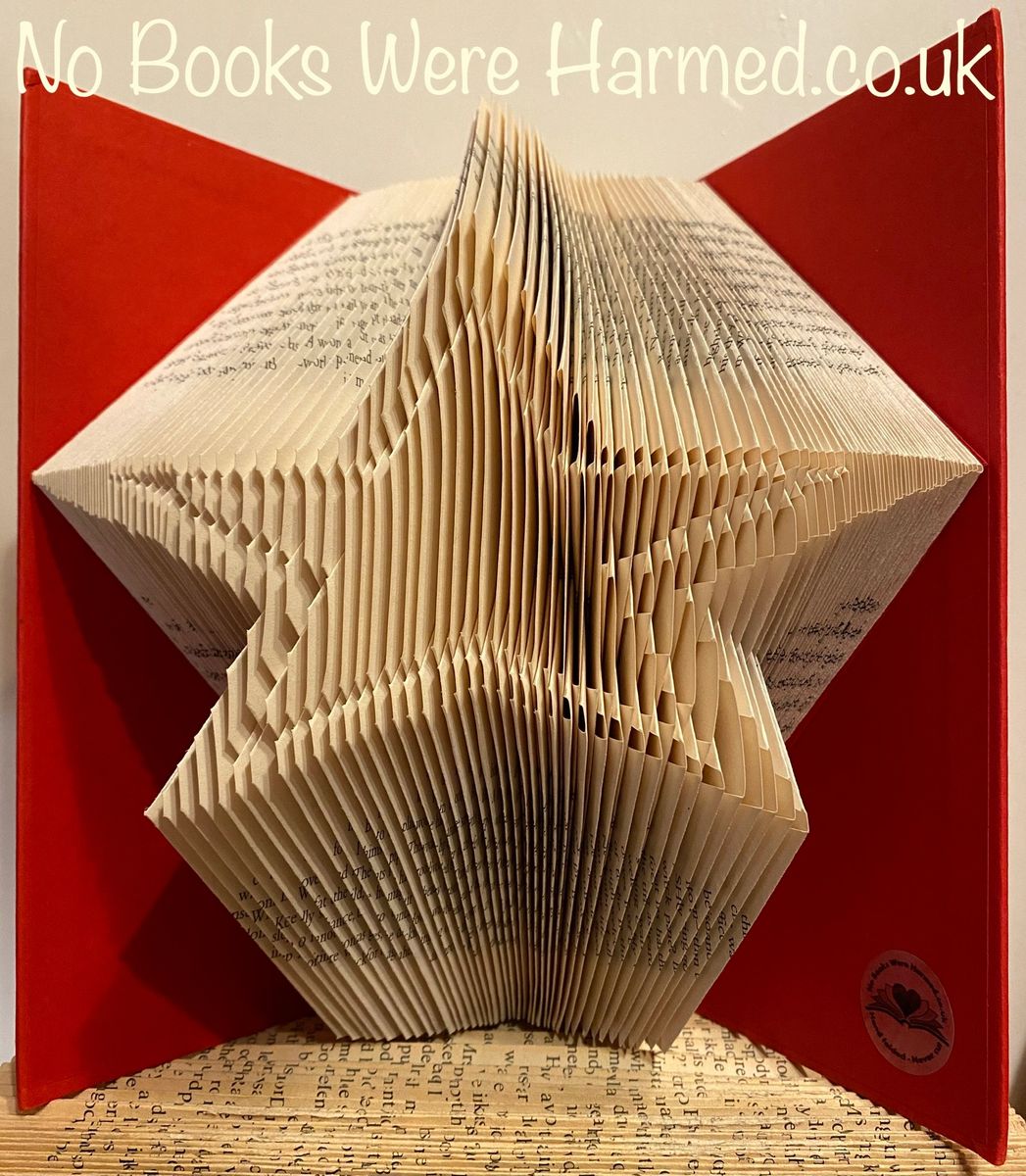 A handcrafted Star Burst art piece made from vintage book pages, showcasing intricate folds and unique design.
