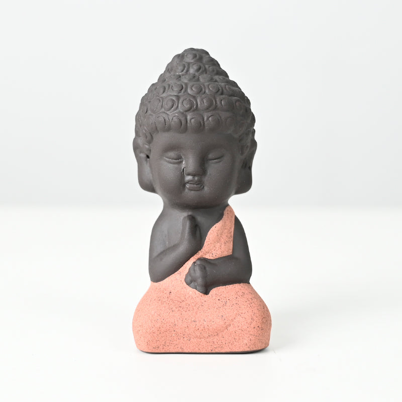 Statue en céramique représentant un moine assis en méditation, exécutant l'abhaya mudra, symbolisant la paix intérieure et l'absence de peur.