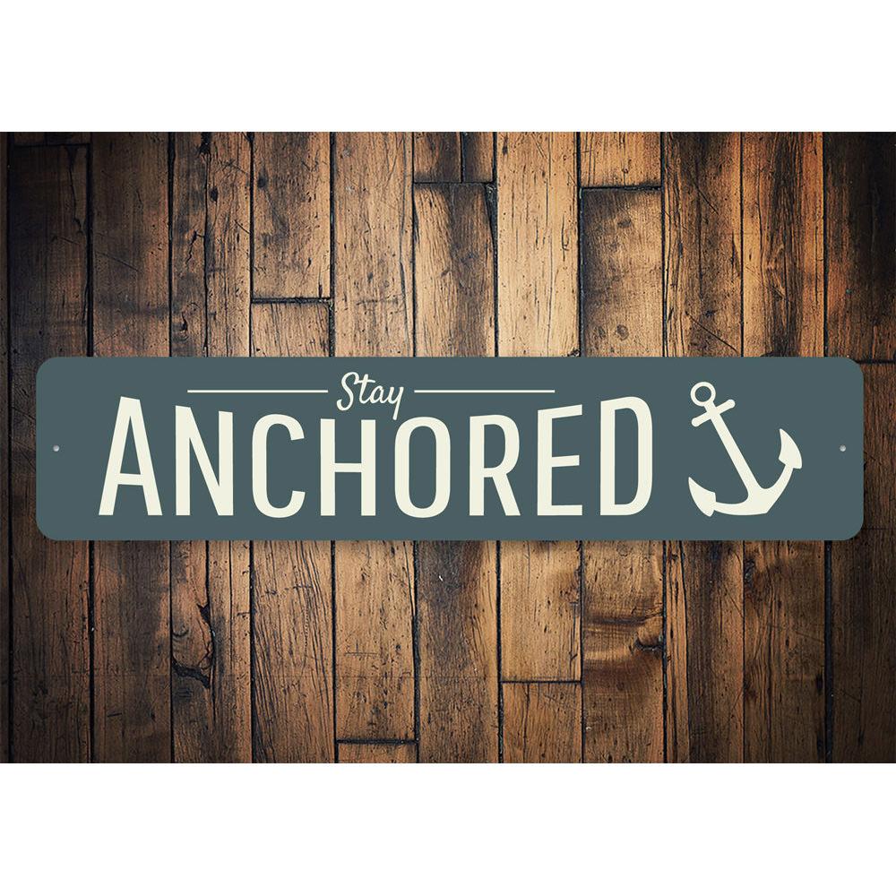 A decorative Stay Anchored Sign made of high-quality aluminum, featuring a beach-themed design, perfect for coastal decor.