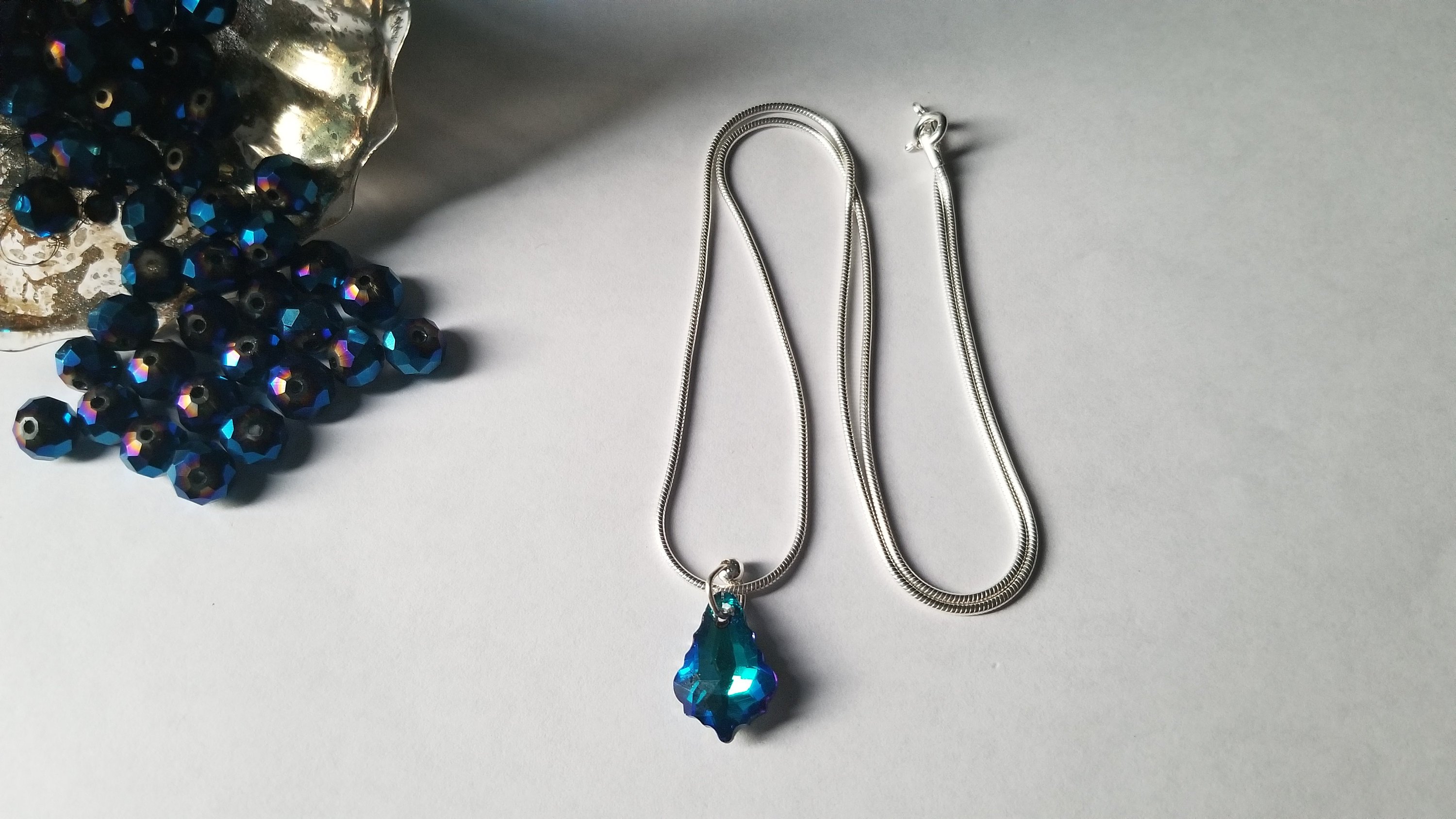 Sterling silver earring and chain set featuring a maple leaf design with blue glass and crystal rhinestones, elegantly displayed.