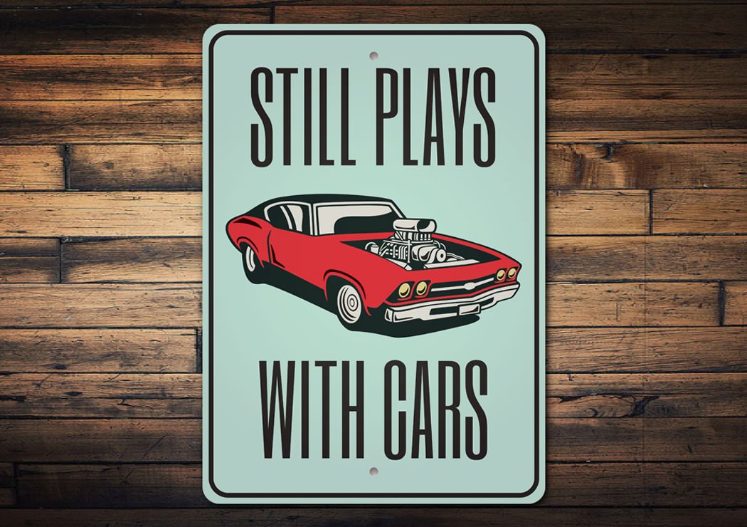 Still Plays With Cars Garage Sign made from high-quality aluminum, featuring a humorous design perfect for car enthusiasts.