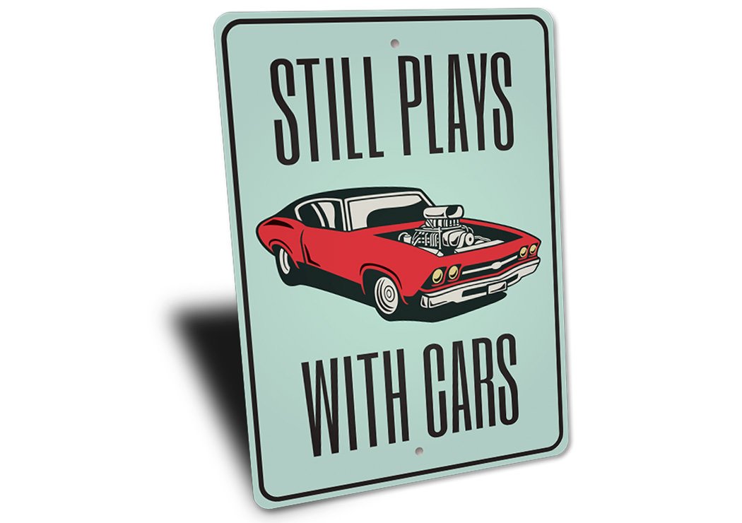 Still Plays With Cars Garage Sign made from high-quality aluminum, featuring a humorous design perfect for car enthusiasts.