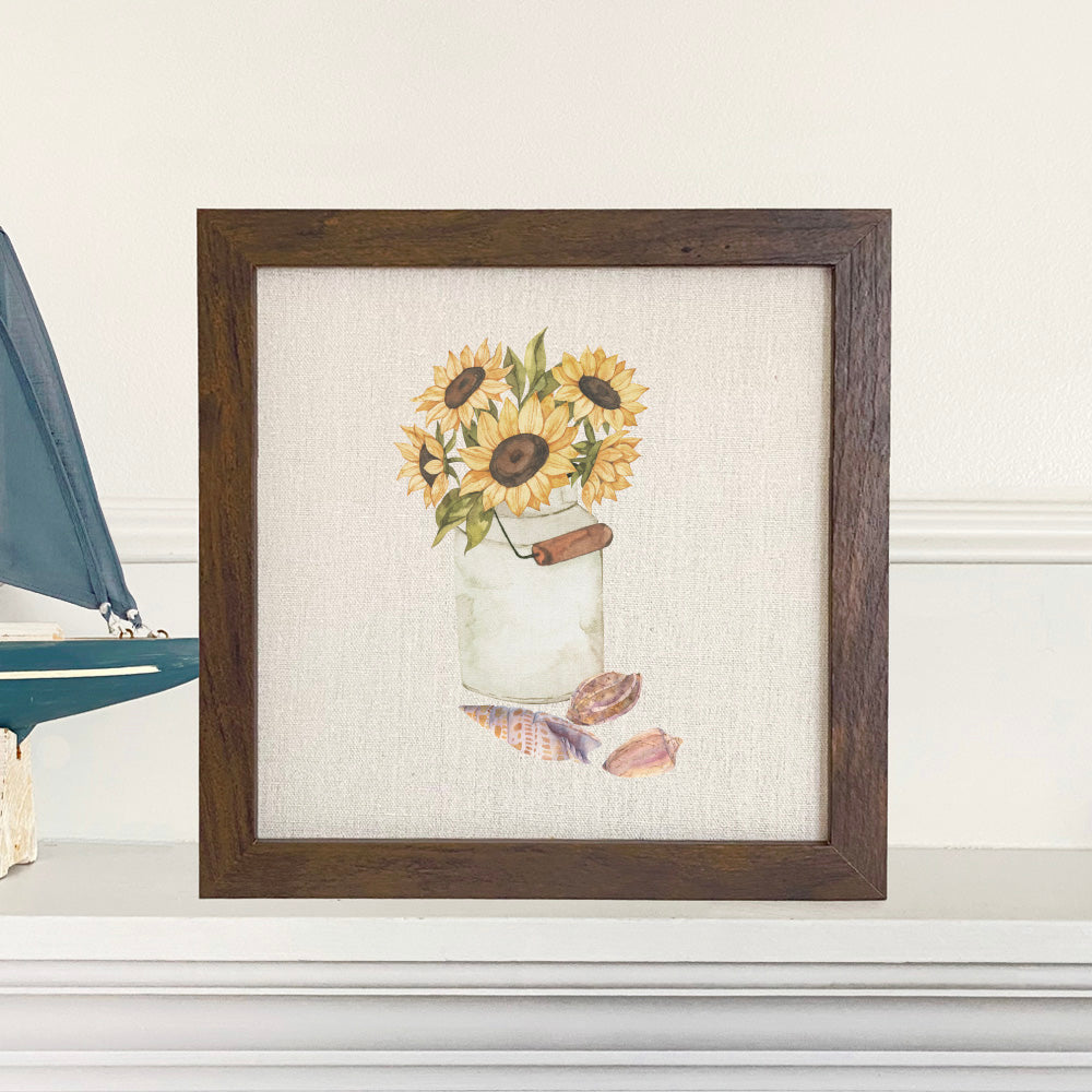 Framed sign featuring sunflowers and seashells with a natural linen-look background and a stylized wood frame.
