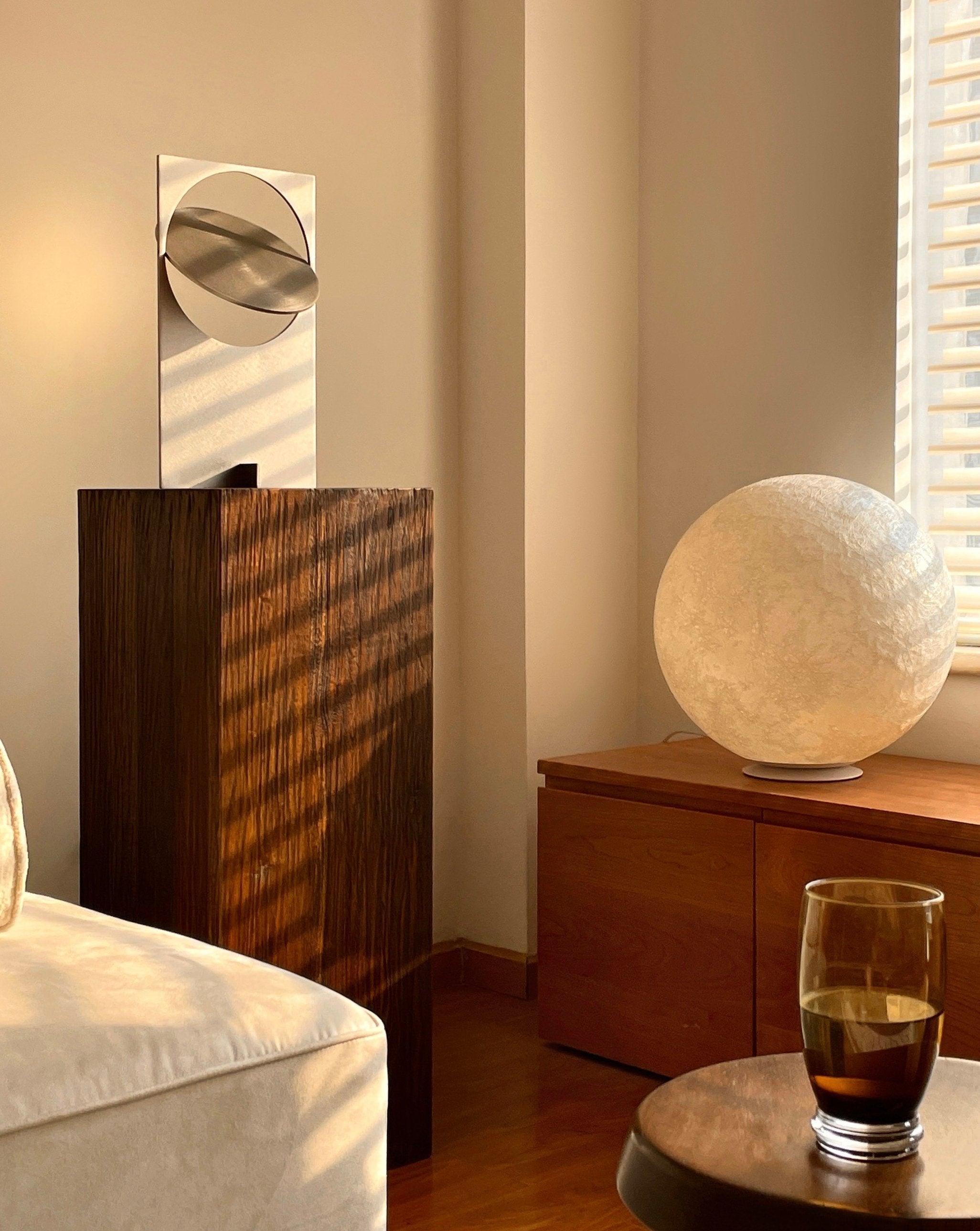 A modern Sunset Table Lamp made of stainless steel, showcasing a unique design that reflects warm light, perfect for living rooms and bedrooms.