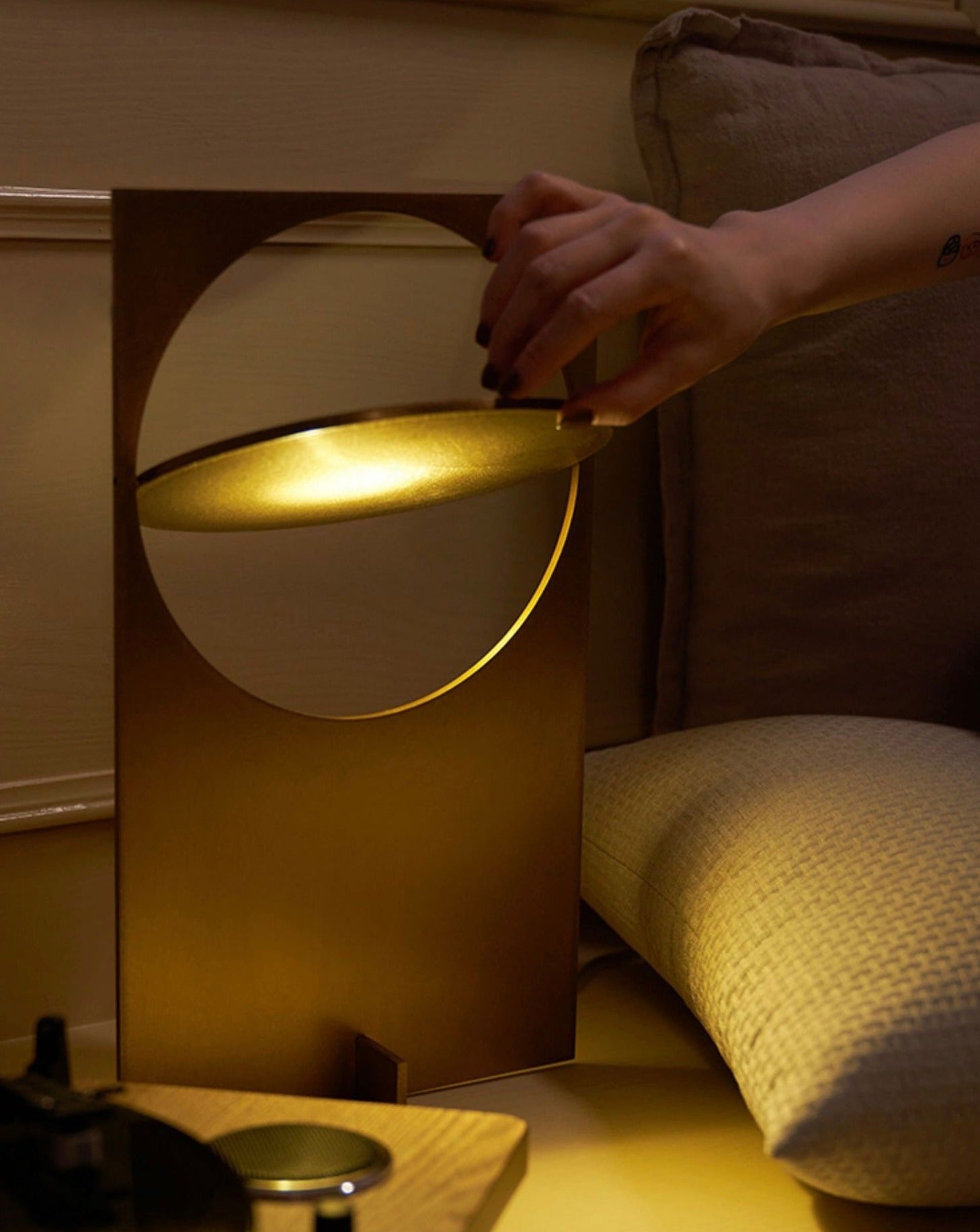 A modern Sunset Table Lamp made of stainless steel, showcasing a unique design that reflects warm light, perfect for living rooms and bedrooms.