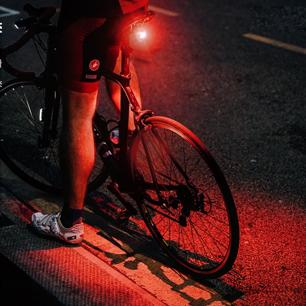 Two bright LED tail lights mounted on a bike's handlebars and seat post, showcasing their visibility and easy installation.