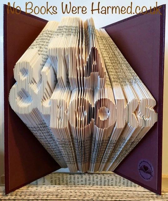 Handcrafted art piece made from vintage book pages, showcasing intricate folded designs and unique colors.