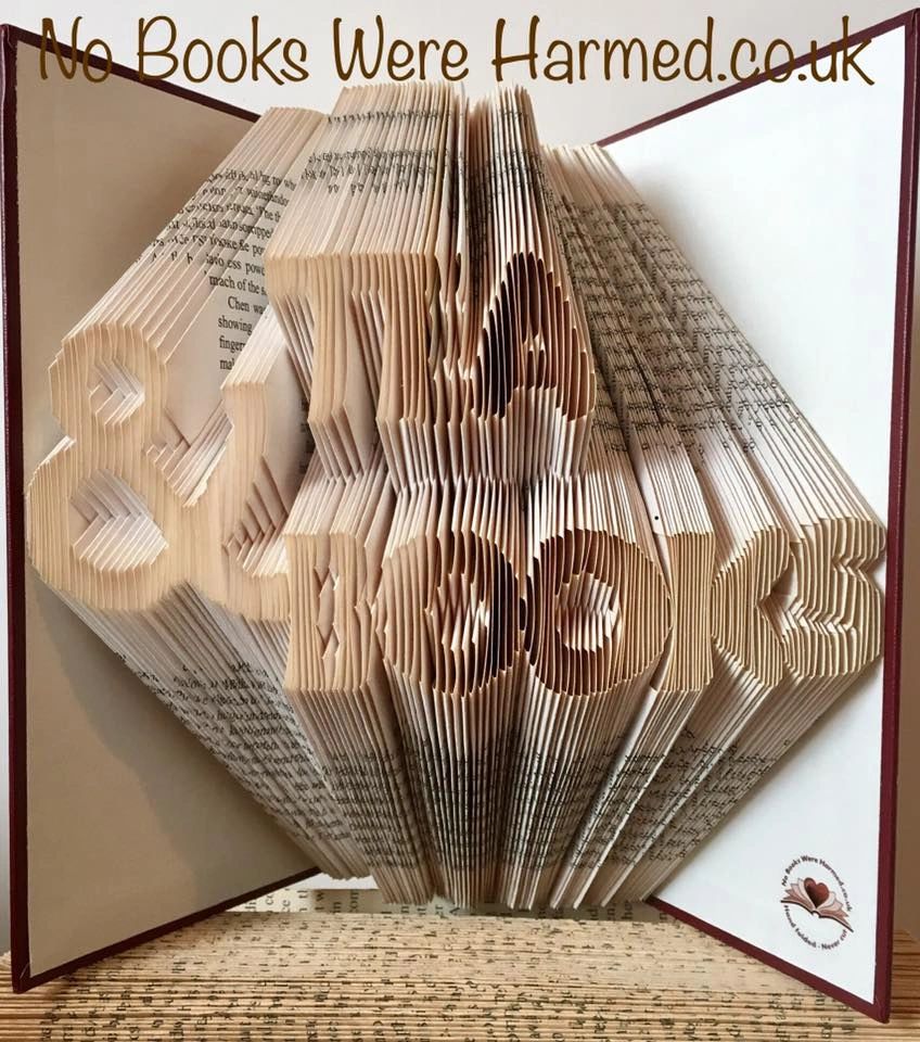 Handcrafted art piece made from vintage book pages, showcasing intricate folded designs and unique colors.