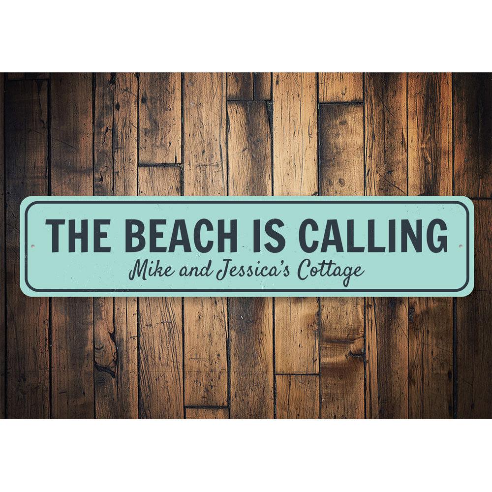 A decorative aluminum sign reading 'The Beach Is Calling', featuring a coastal design, perfect for home decor.