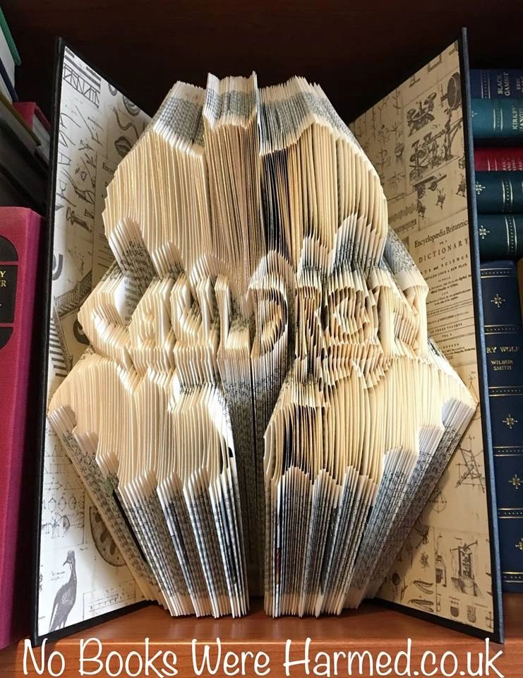A handcrafted book sculpture titled Cauldron of Bats, featuring intricate folds and gilded edges, showcasing a unique design perfect for bibliophiles.