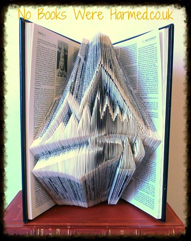 Handcrafted book art titled 'The Mountains Are Calling', made from vintage Encyclopaedia Britannica pages, showcasing intricate folds and unique design.