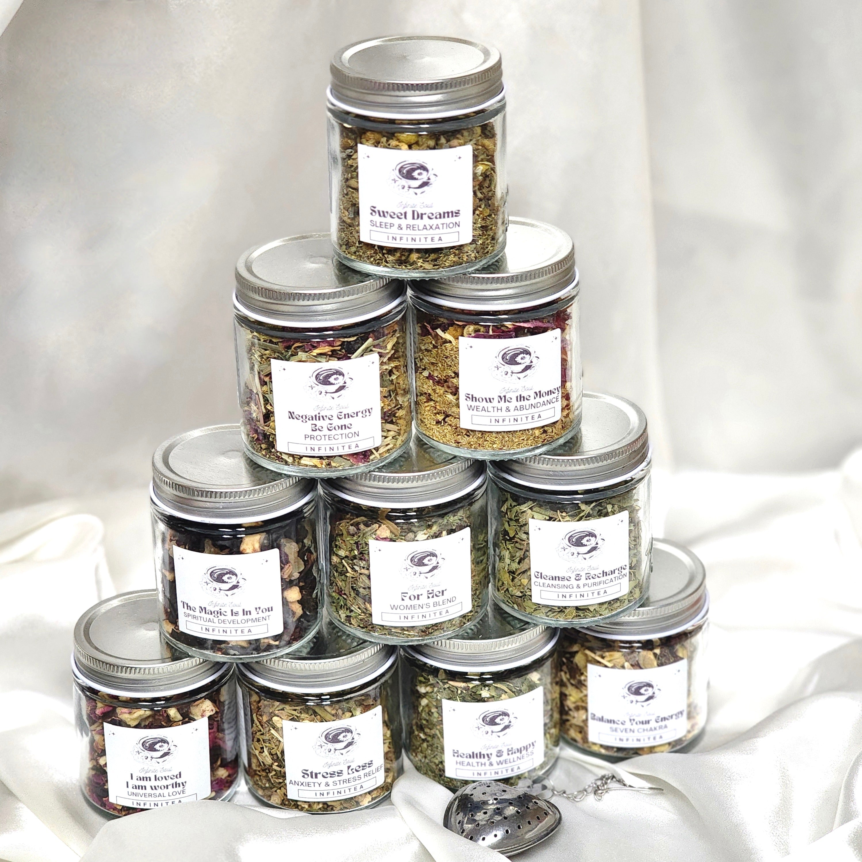 The Complete Infinitea Collection Bundle Pack featuring 10 Organic Herbal teas and a Strawberry Tea Infuser, beautifully arranged.