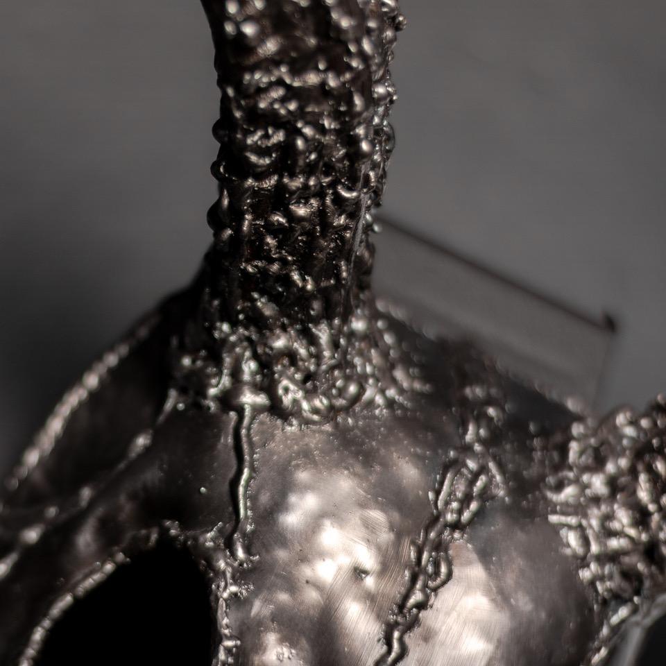 Handcrafted metal sculpture of an eight-point buck skull, showcasing intricate details and a rustic finish.