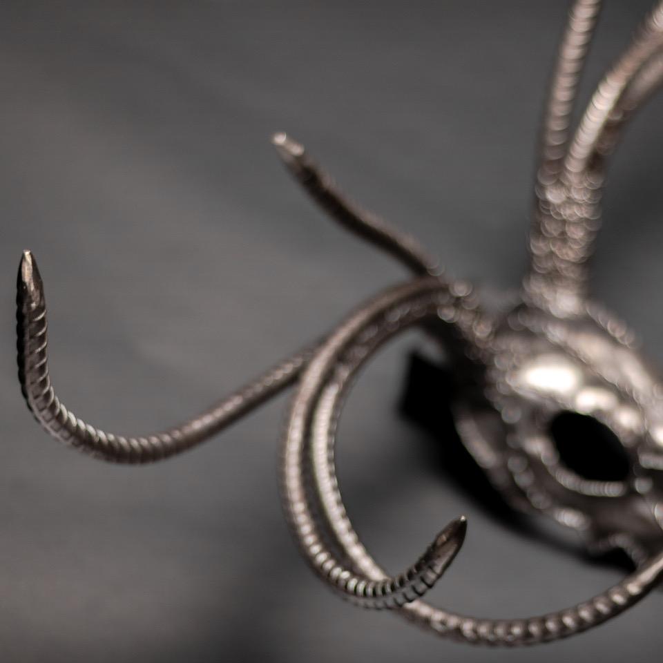 Handcrafted metal sculpture of an eight-point buck skull, showcasing intricate details and a rustic finish.