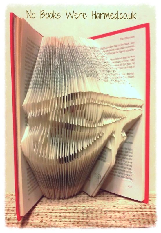 Handcrafted Eye of Horus art made from folded pages of vintage books, showcasing intricate designs and unique colors.