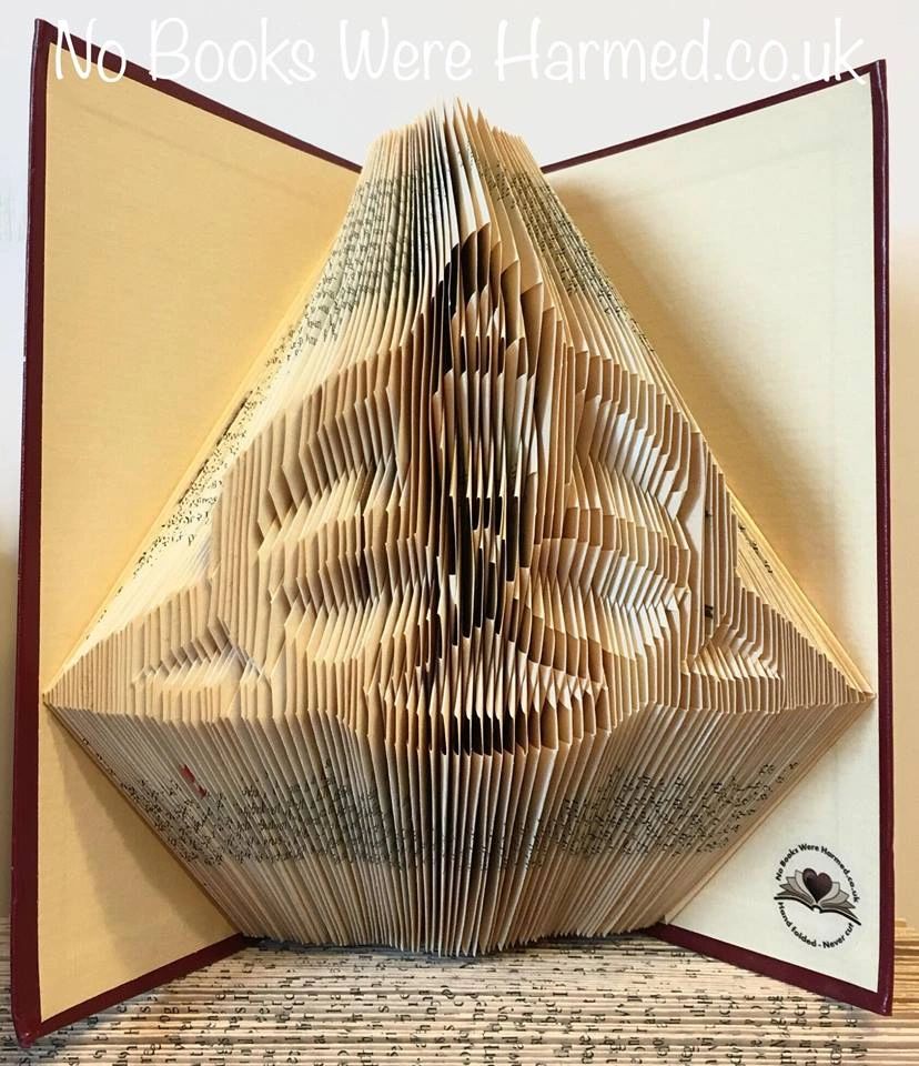 Handcrafted Triquetra art piece made from vintage book pages, showcasing intricate folds and unique design.