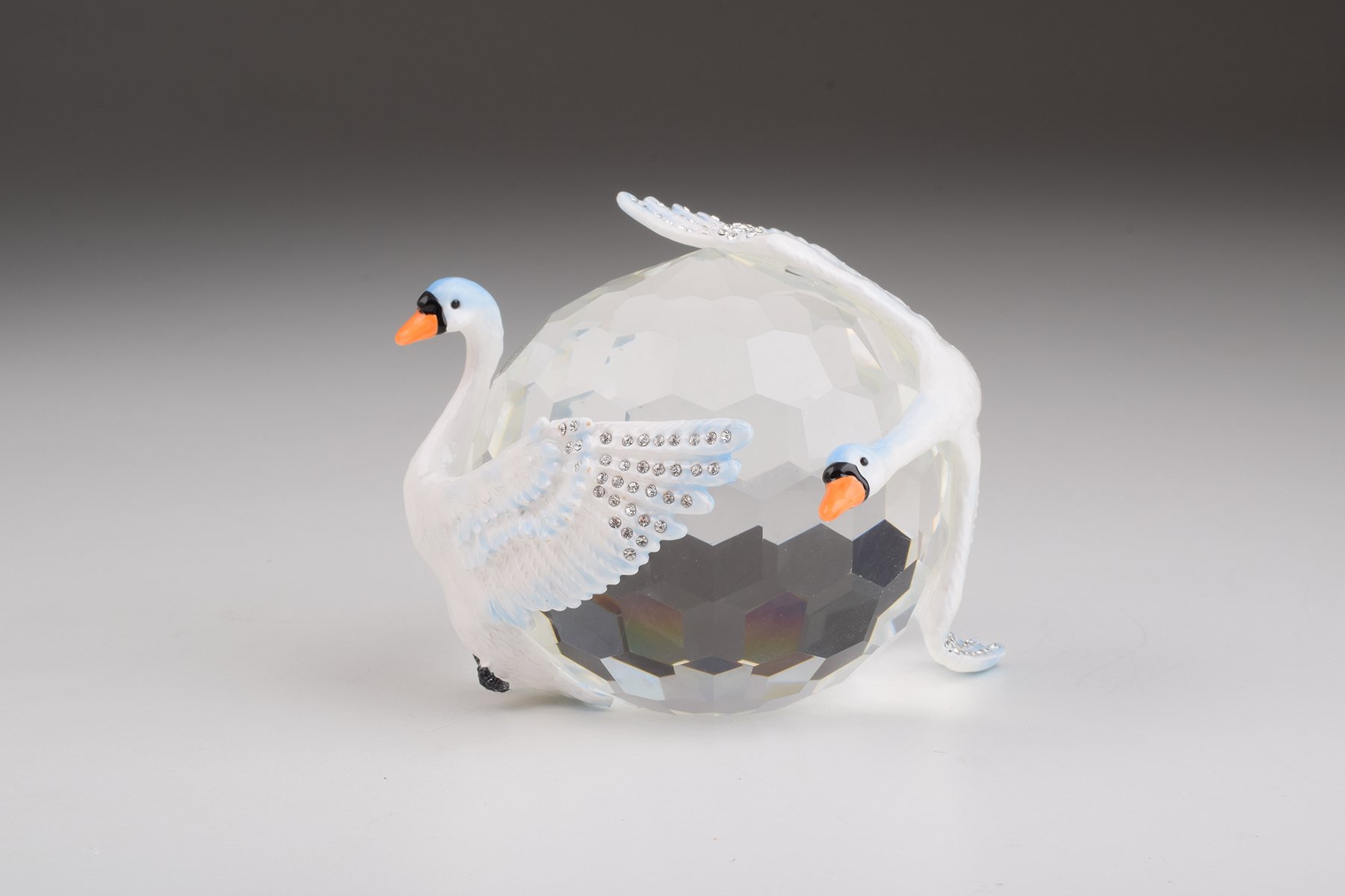 Elegant trinket box featuring two white swans on a crystal ball, adorned with Austrian crystals and plated with gold or silver.
