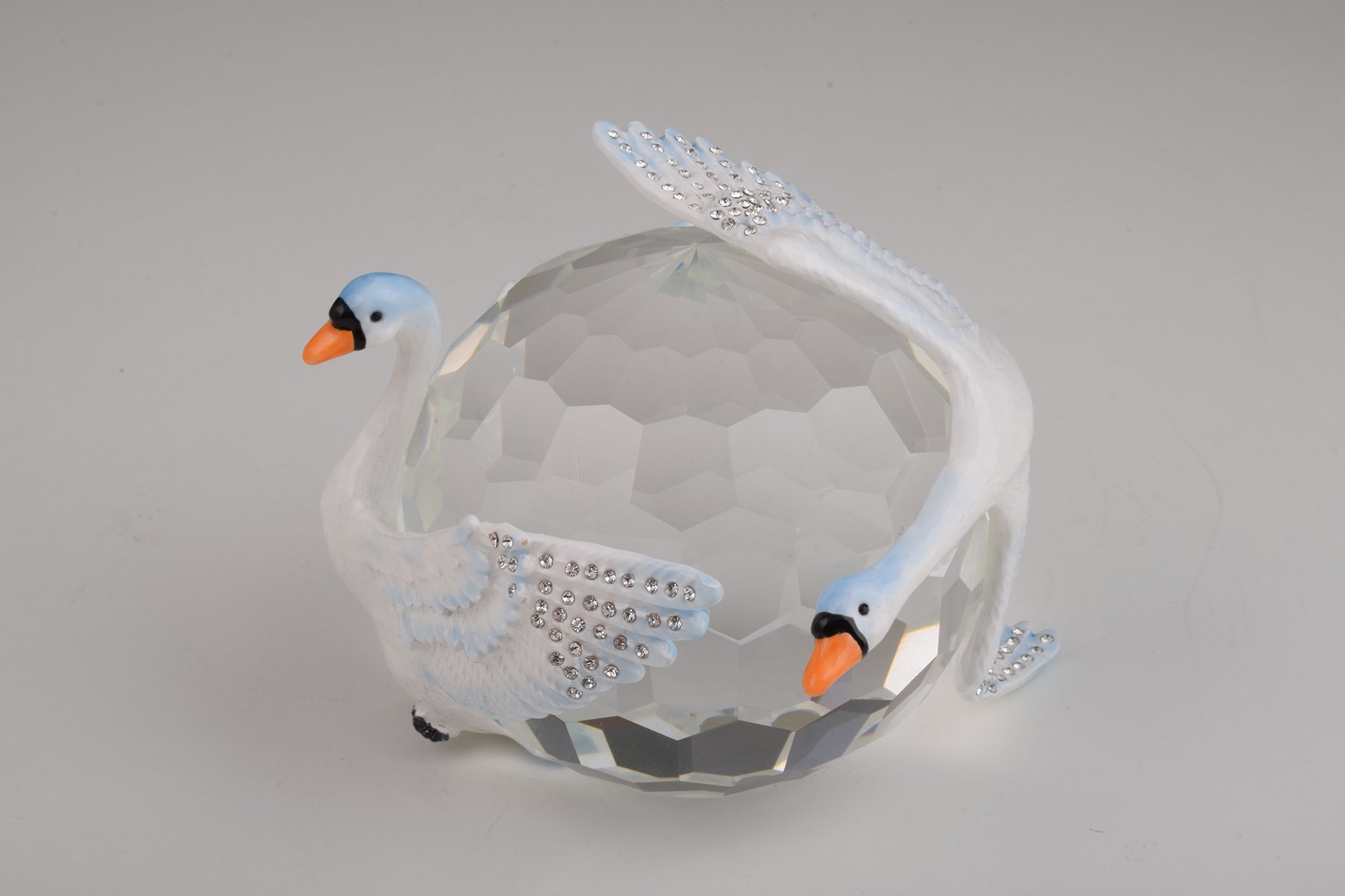 Elegant trinket box featuring two white swans on a crystal ball, adorned with Austrian crystals and plated with gold or silver.
